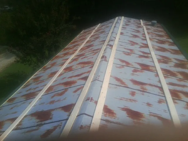 Rusted metal roof panels with new wood purlins before replacement — Storm Damage Roof Repair in Dover AFB by Roofing Brothers