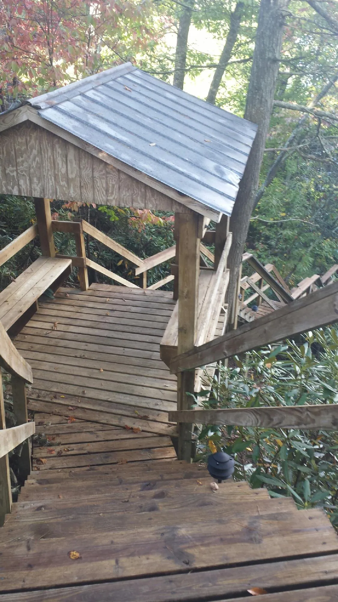 Metal roofed shelter over wooden steps on a wooded walkway — Skylight Repair & Installation work by our crew in Dover AFB
