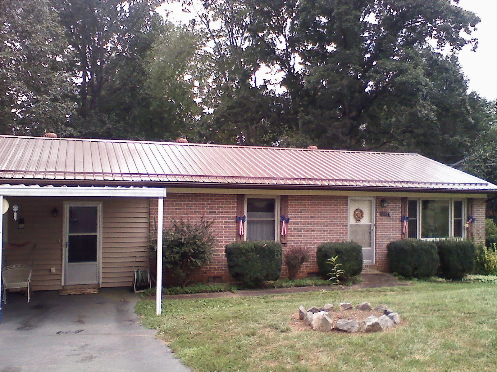 Bronze metal roof and carport on a brick ranch home — Roof Repair work by our crew in Dover AFB