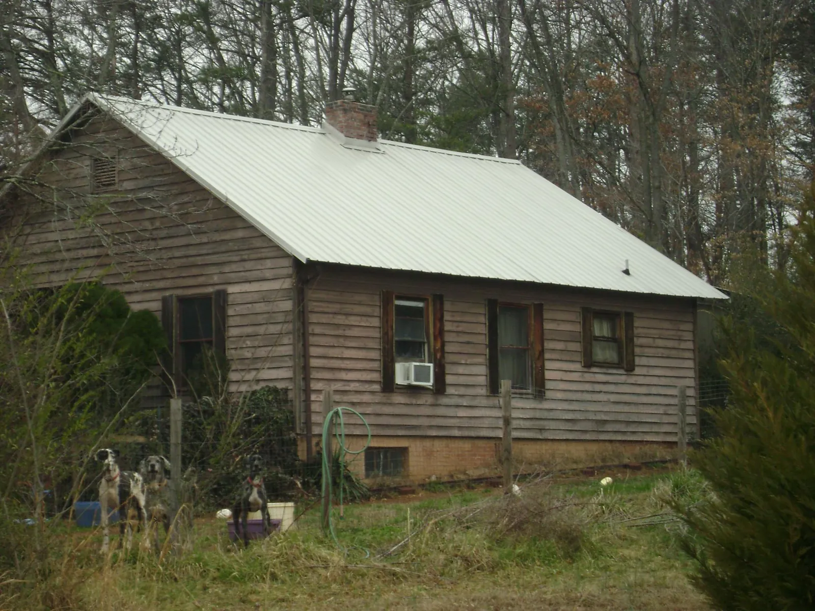 White metal roof on an old wood sided farmhouse, from a Asphalt Shingle Roof Repair job in Dover AFB